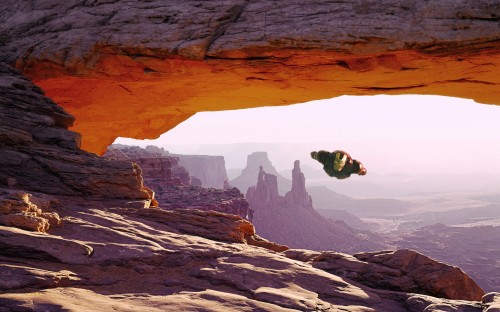 iron man flying through a natural arch